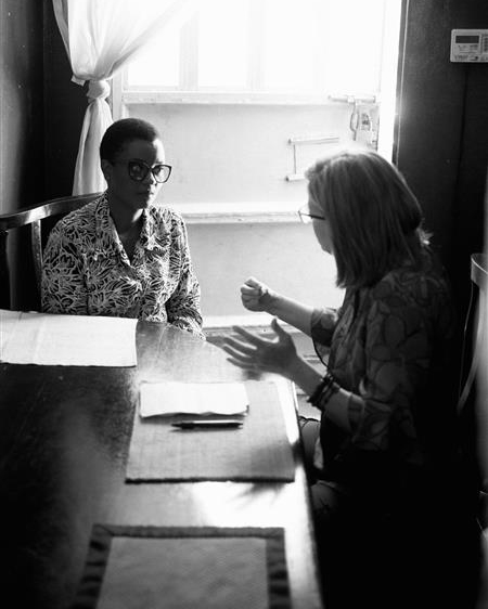 A white woman interviewing an African woman.