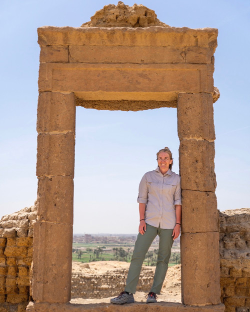 Kathy Berrett standing under an arch at an archeological site in Egypt