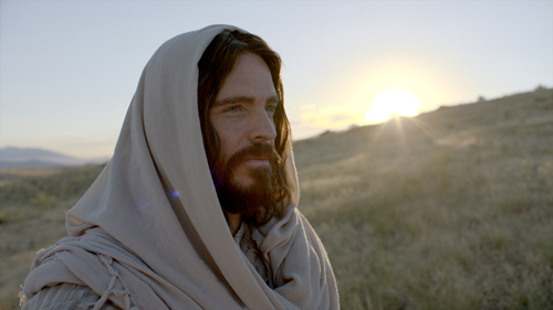 Jesus Christ smiling with a sunset in the background